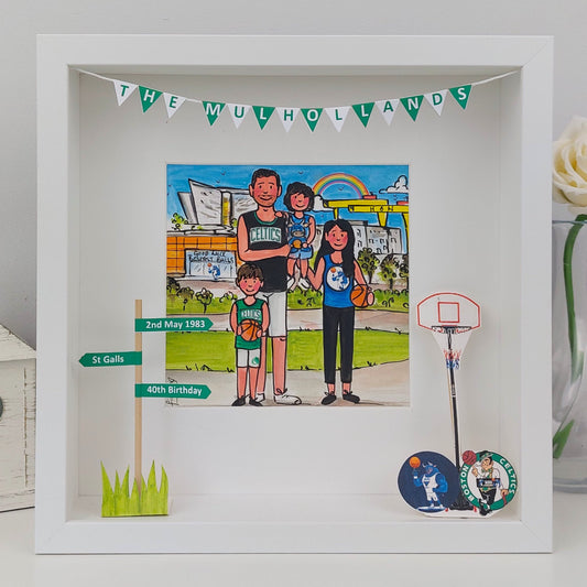 Framed artwork of a family with basketball-themed elements on a white surface.  Belfast scenery in the background