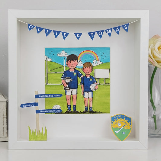 Framed artwork of two boys in sports uniforms with a rainbow and 'Ollie & Thomas' banner.