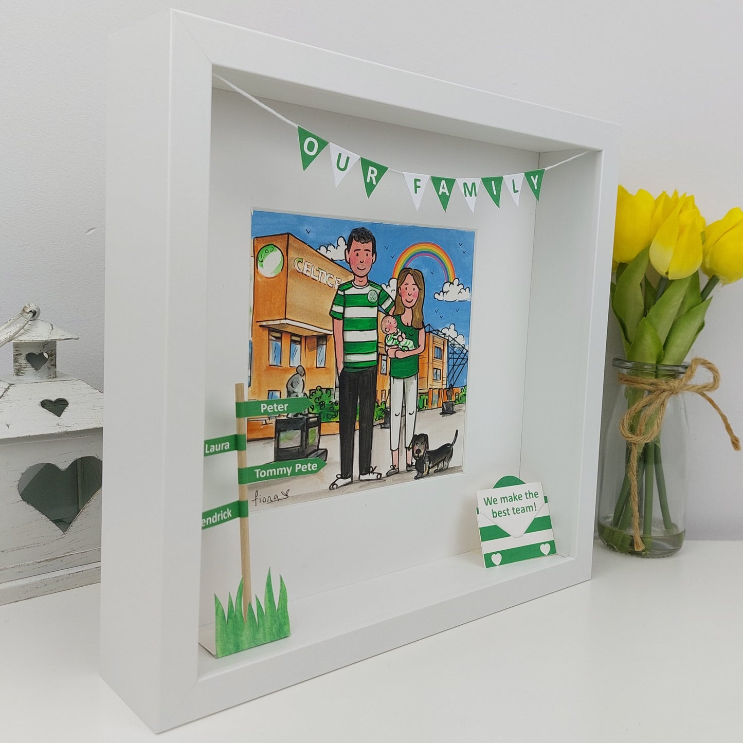 Framed illustration of a couple with a dog, surrounded by decorative elements on a white surface.