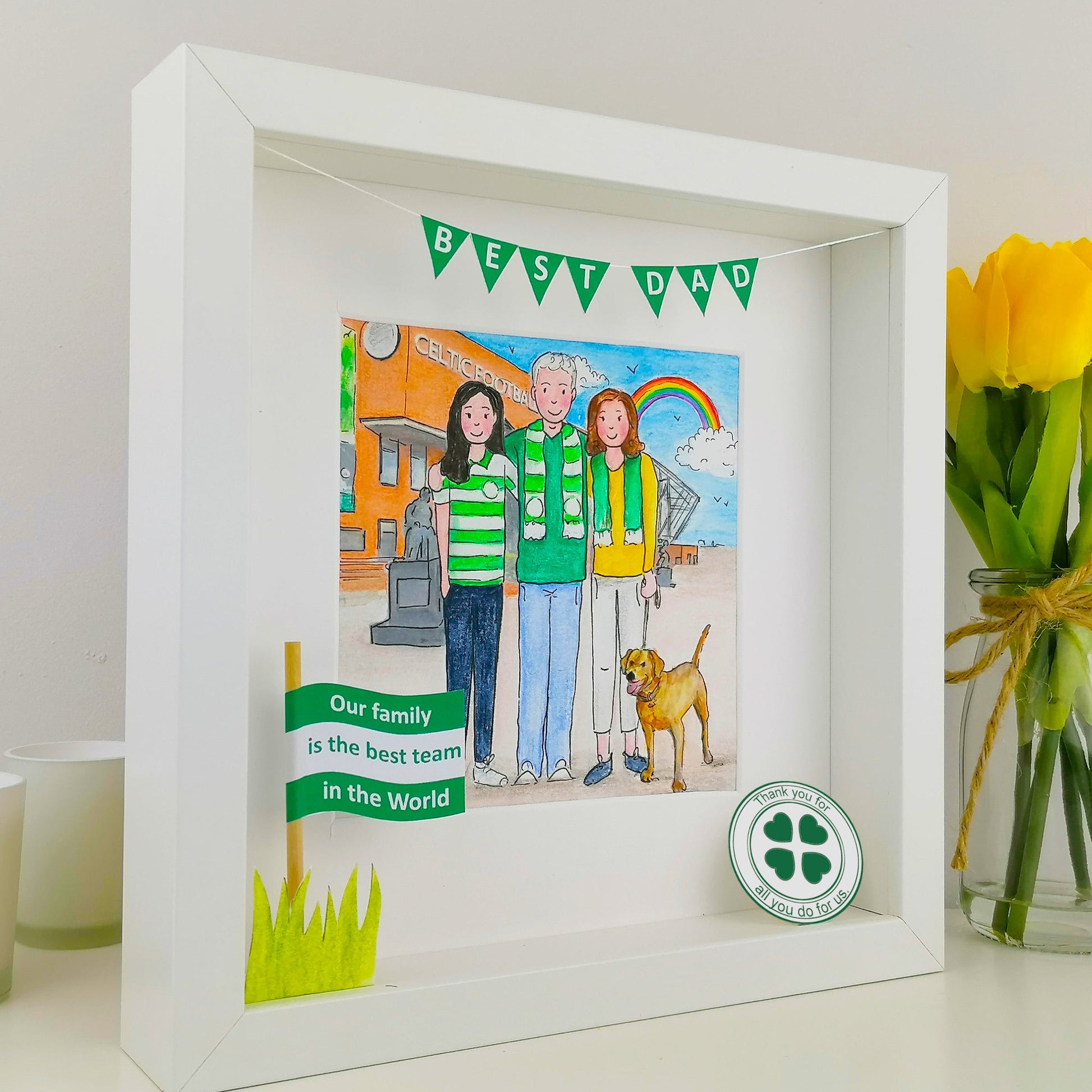 White framed artwork with a family illustration and 'Best Dad' text, featuring a green four-leaf clover symbol.