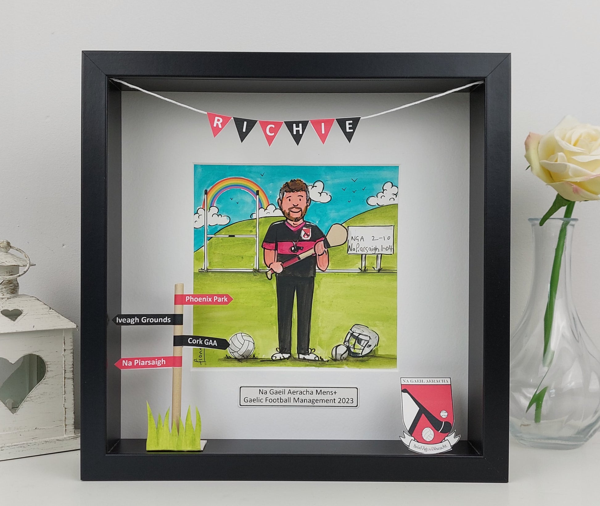 Framed artwork of a cartoon character holding a tennis racket on a grass field, with text and graphics around it.