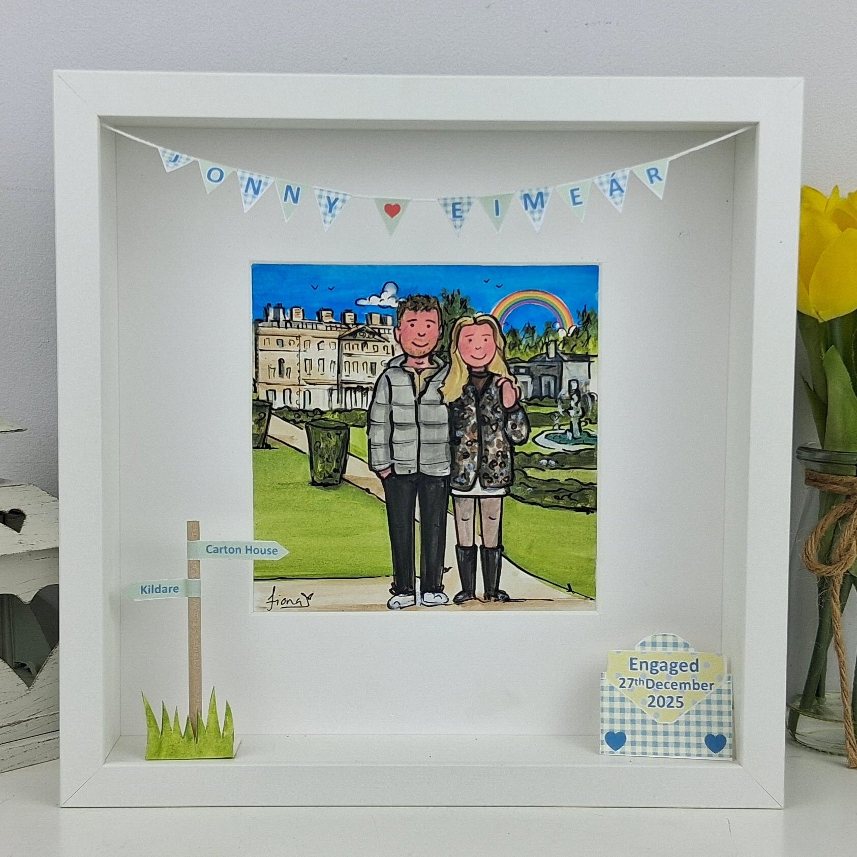 Framed artwork of a couple in a park with decorative elements and text.