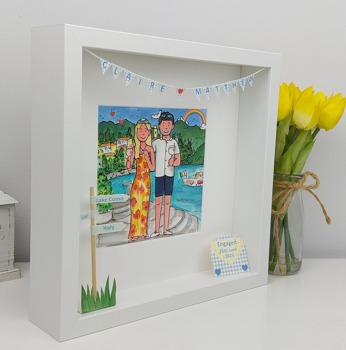 Framed illustration of a couple on a lake with a vase of yellow tulips.