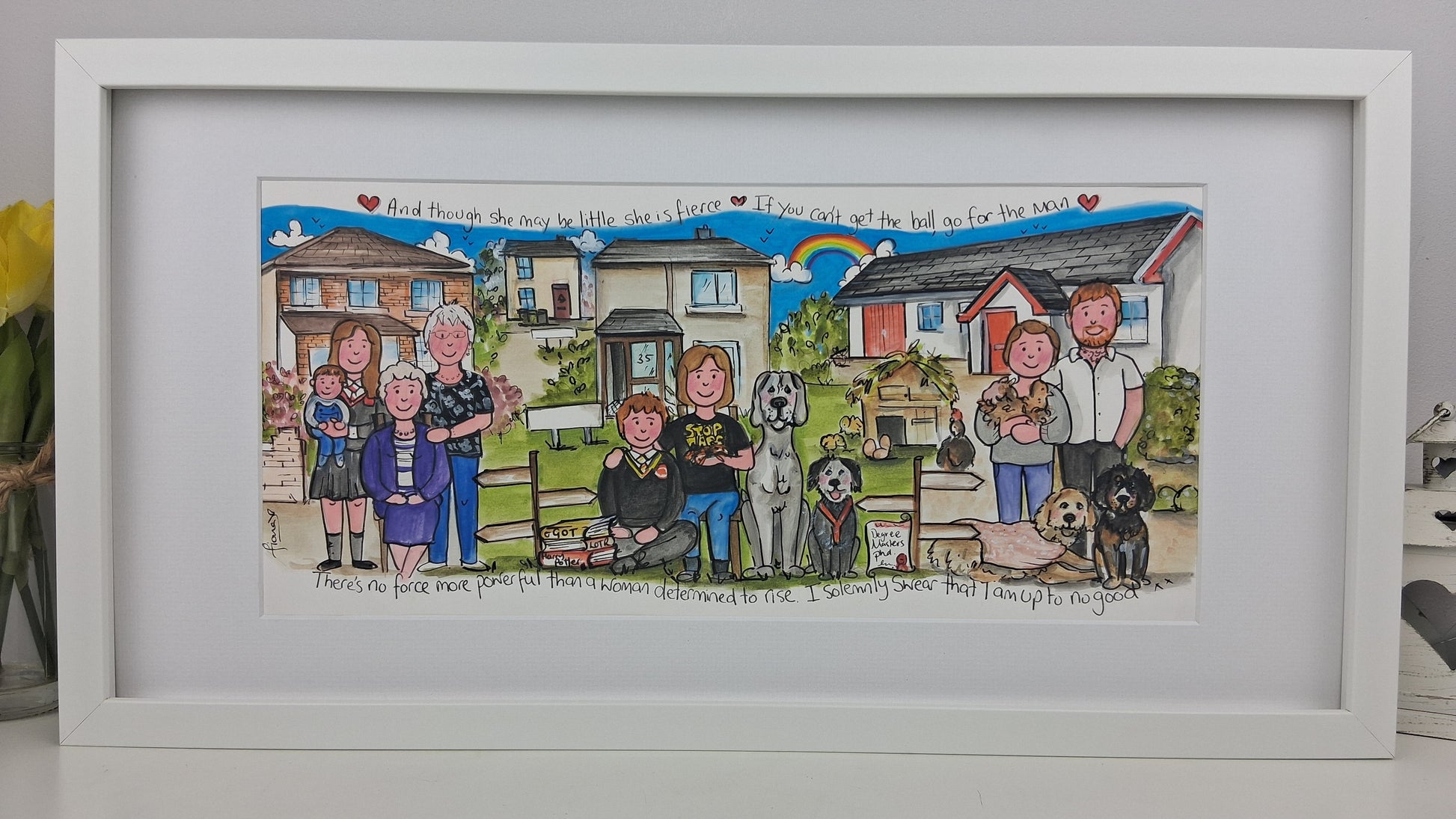 Framed artwork of a family with pets in a suburban setting