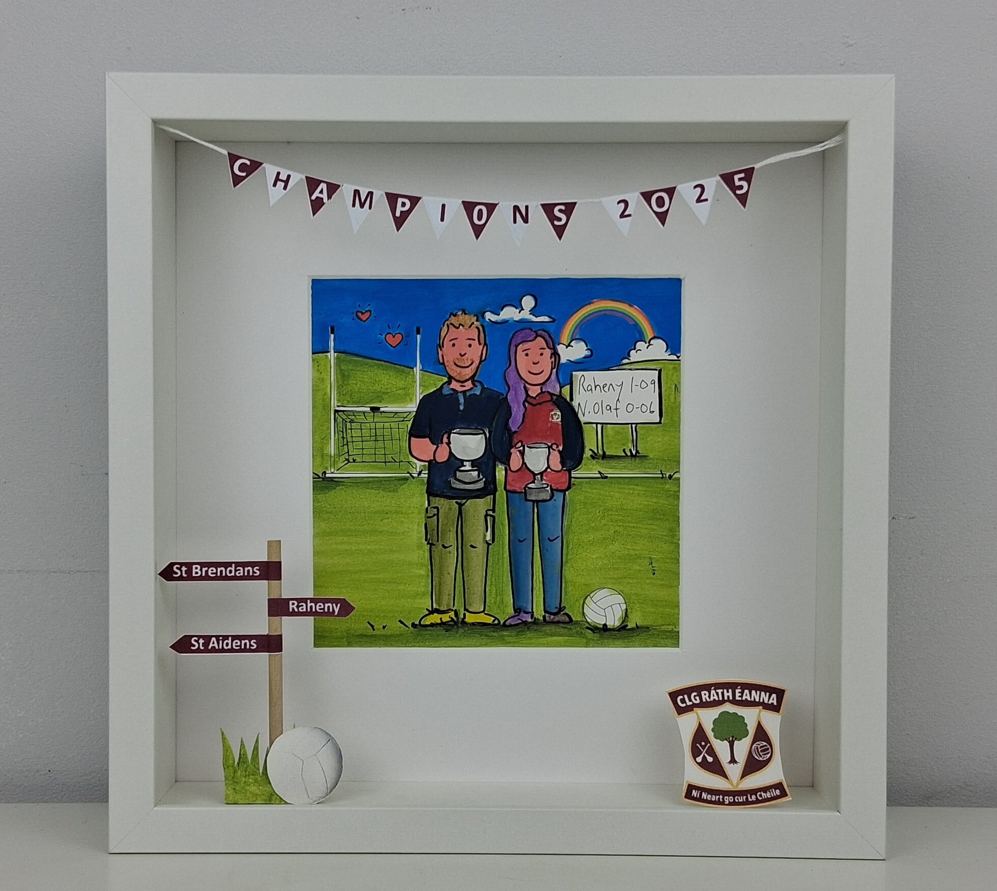 Framed artwork of two people holding trophies on a sports field with 'Champions 2025' banner.