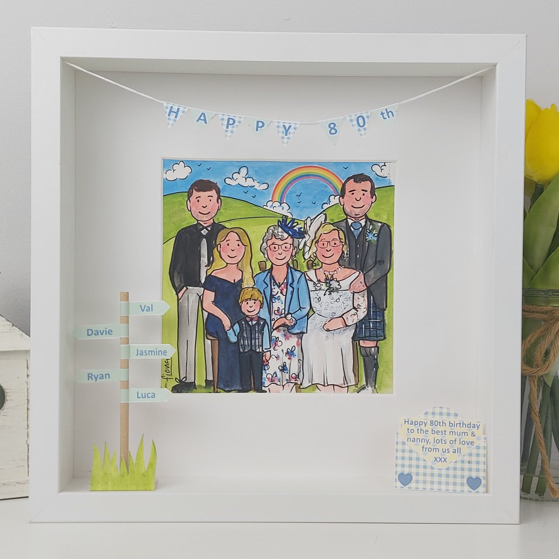 Framed illustration of a family with a 'Happy 80th' banner, surrounded by flowers and decorative items.
