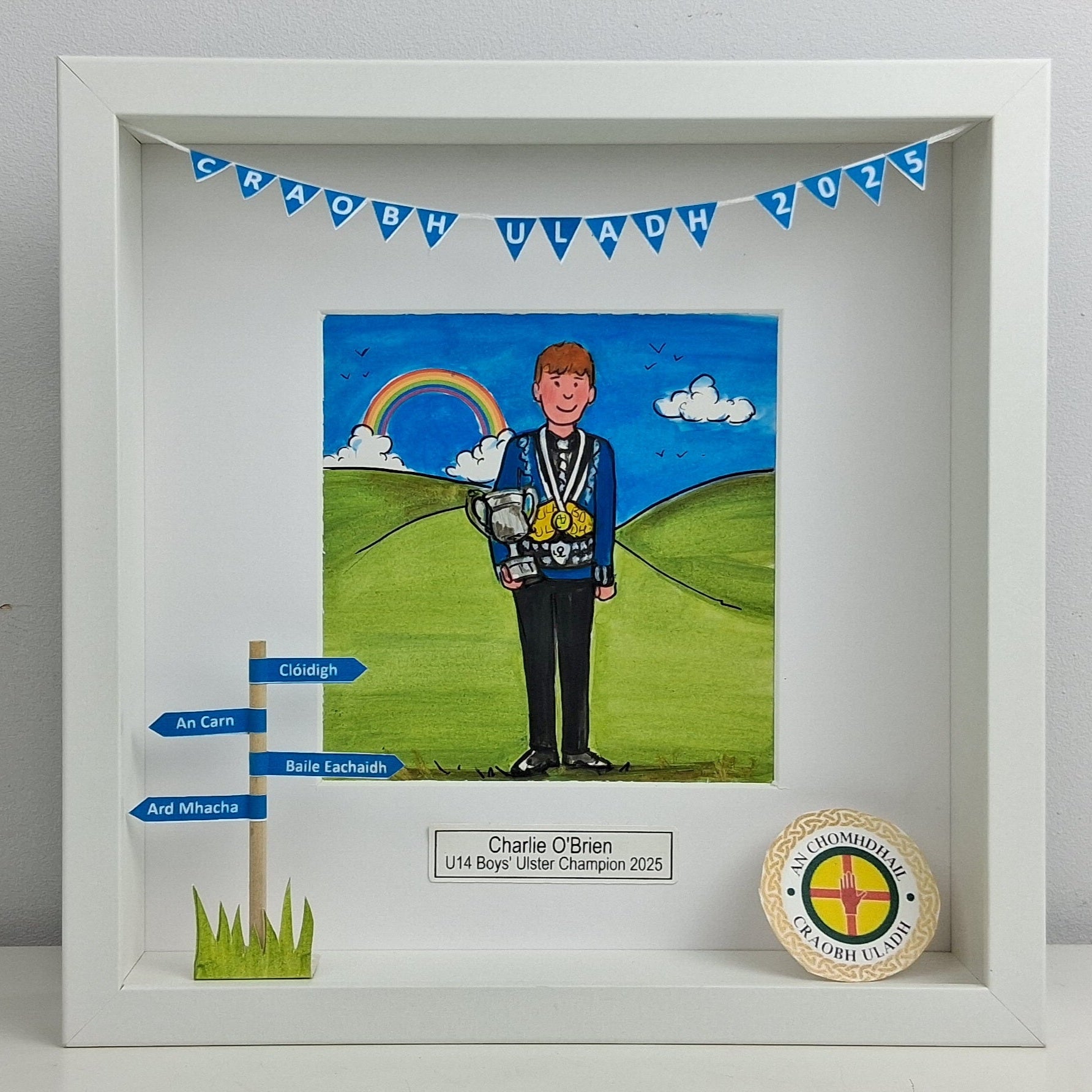 Framed artwork of a boy irish dancer holding a trophy with a rainbow and clouds in the background, featuring text and a badge.
