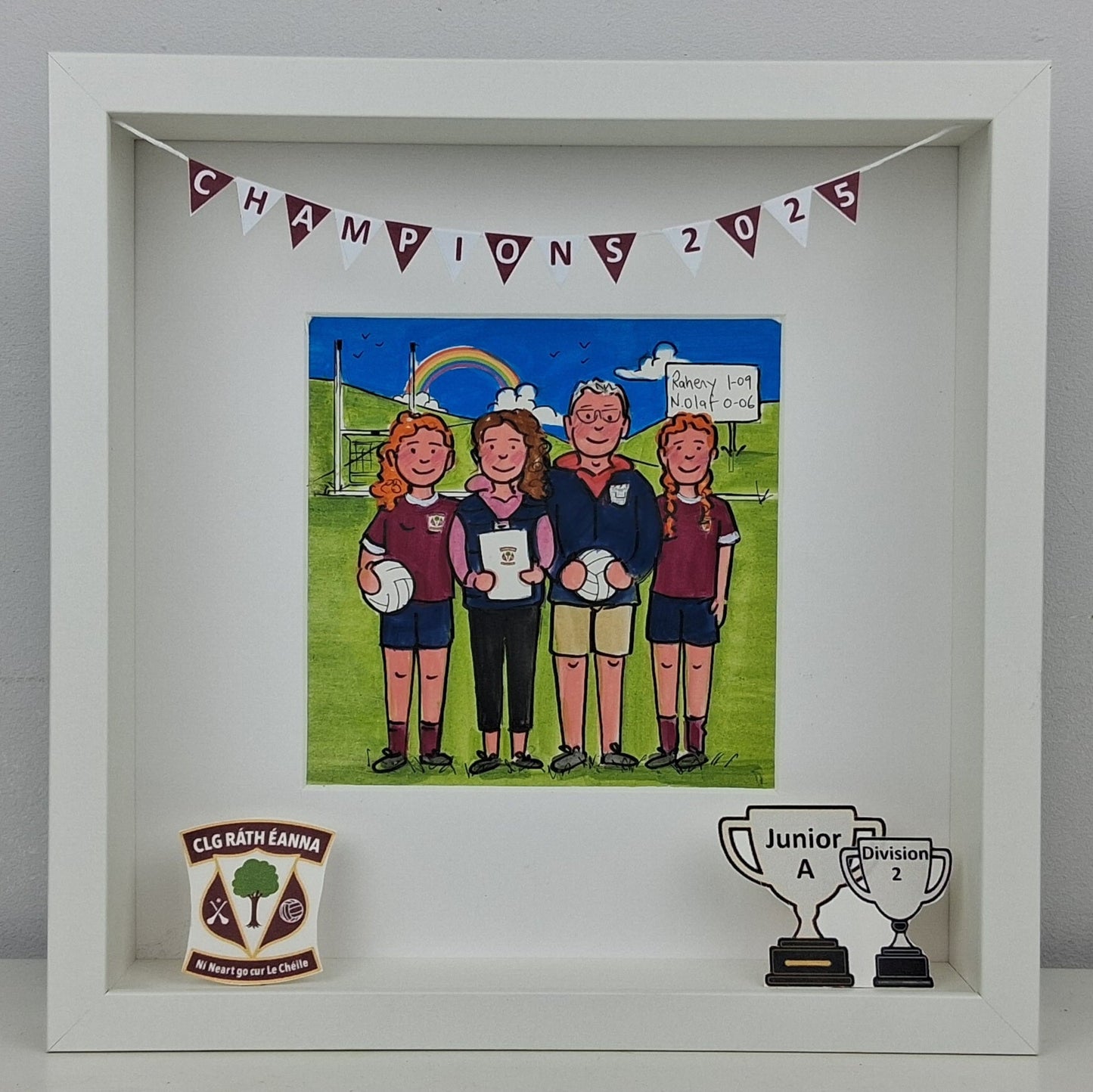 Framed artwork of a group of people on a sports field with 'Champions 2025' banner.