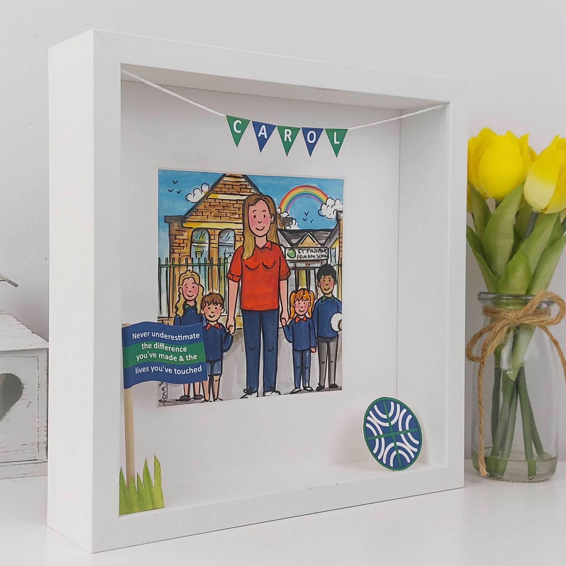 Shadow box with illustration of a woman with children and motivational quote, next to a vase of yellow tulips.