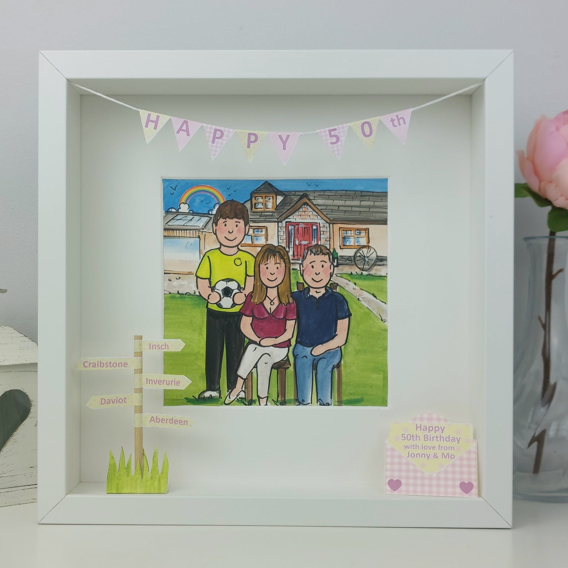 Framed artwork of a family with a 'Happy 50th' banner, Mum and son and husband