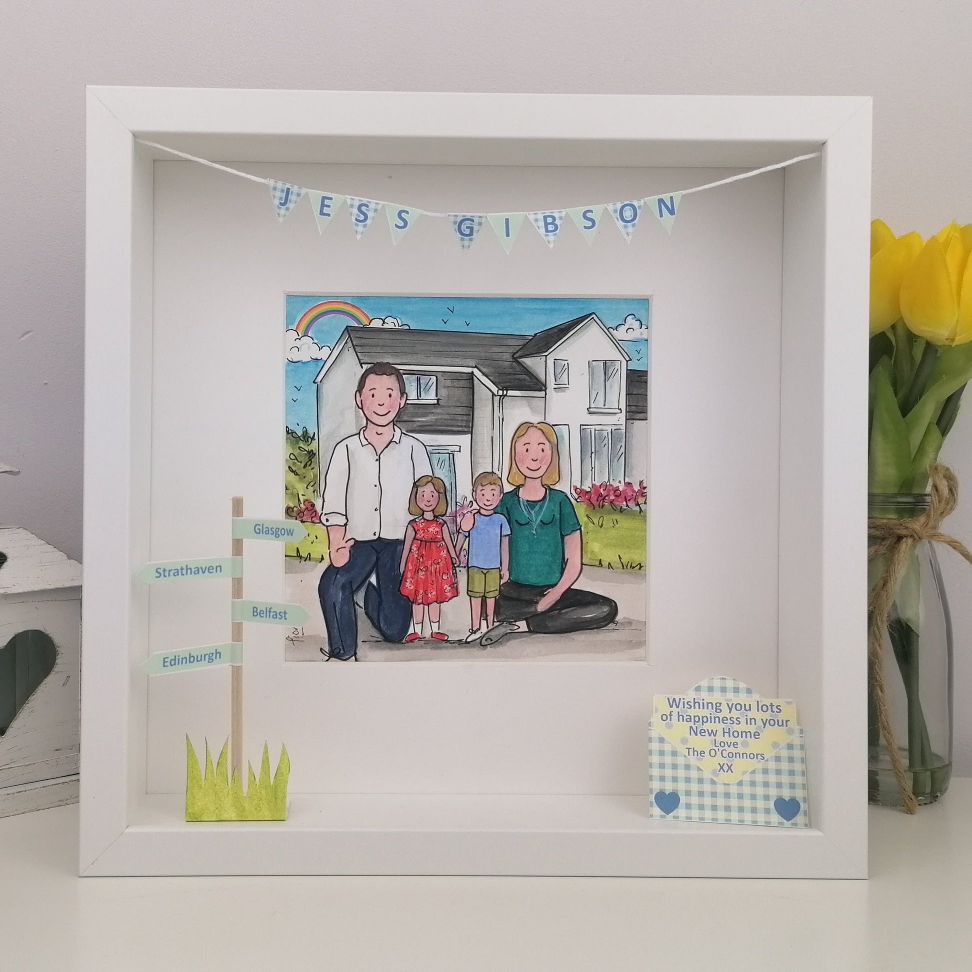Framed illustration of a family in front of a house with decorative elements in a white box frame