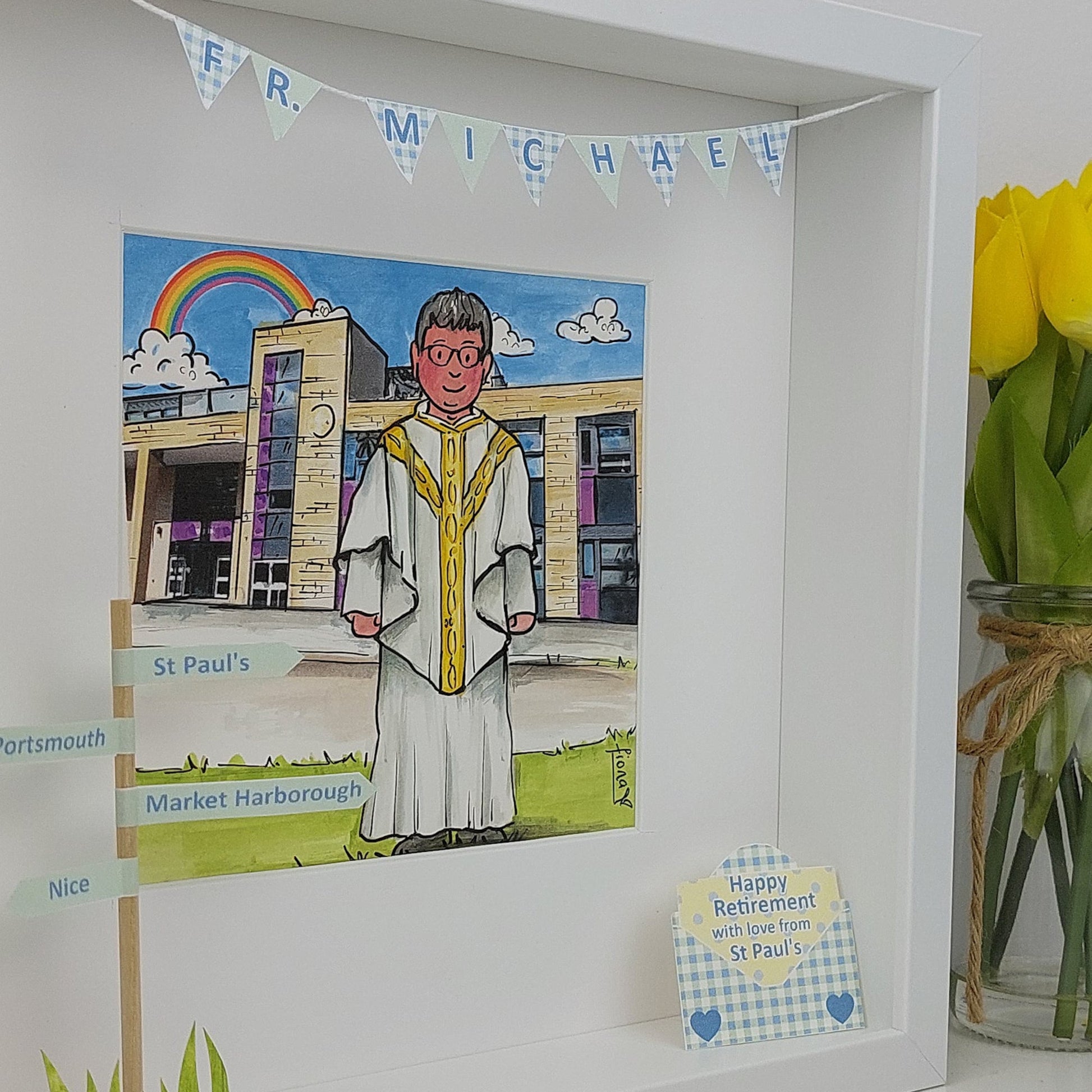 Framed picture of a cartoon character in religious attire with a rainbow and building in the background, on a white wall.