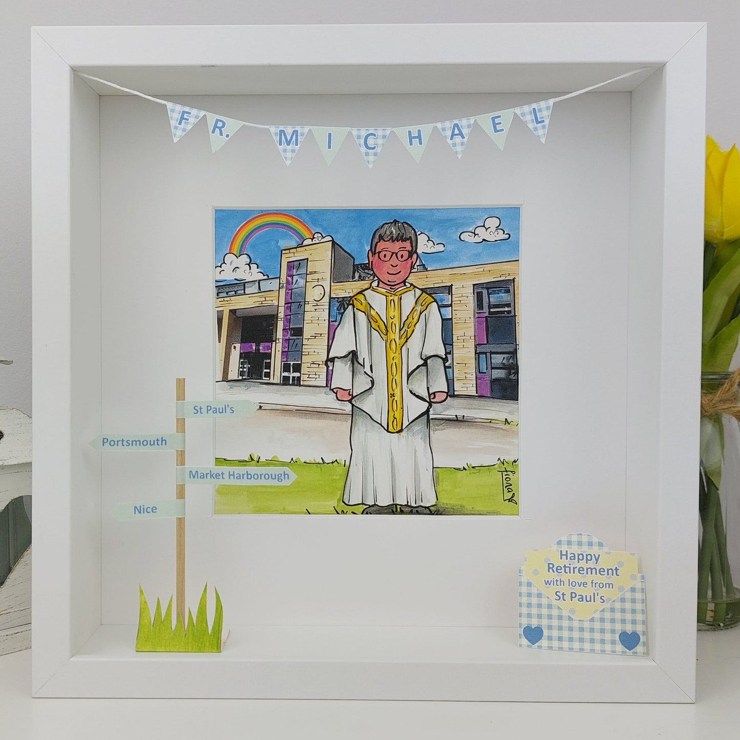 Framed artwork of a person in religious attire with a rainbow and building illustration, featuring text and decorative elements.