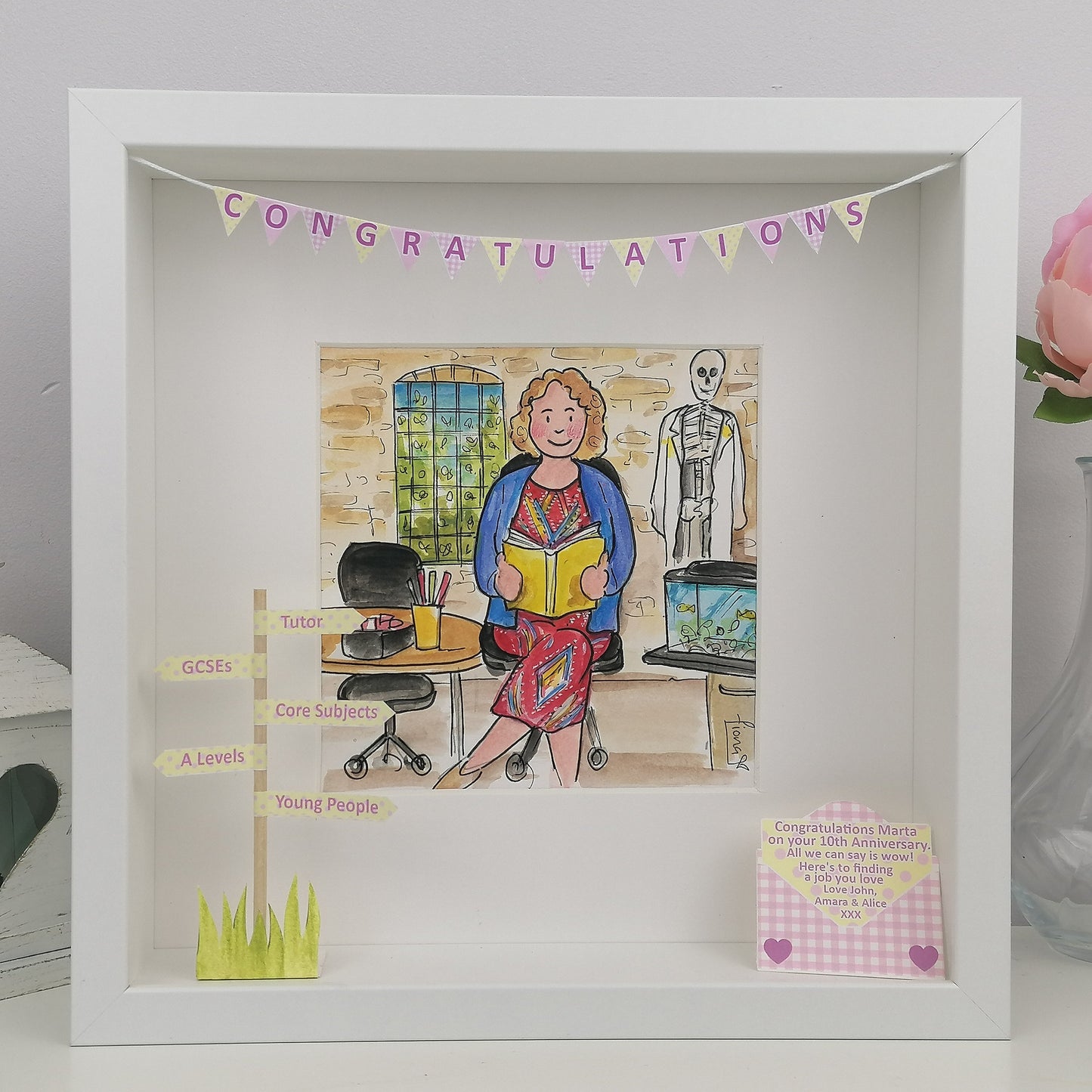 Decorative framed artwork with a cartoon illustration of a woman in an office setting, 'Congratulations' banner, and decorative elements.