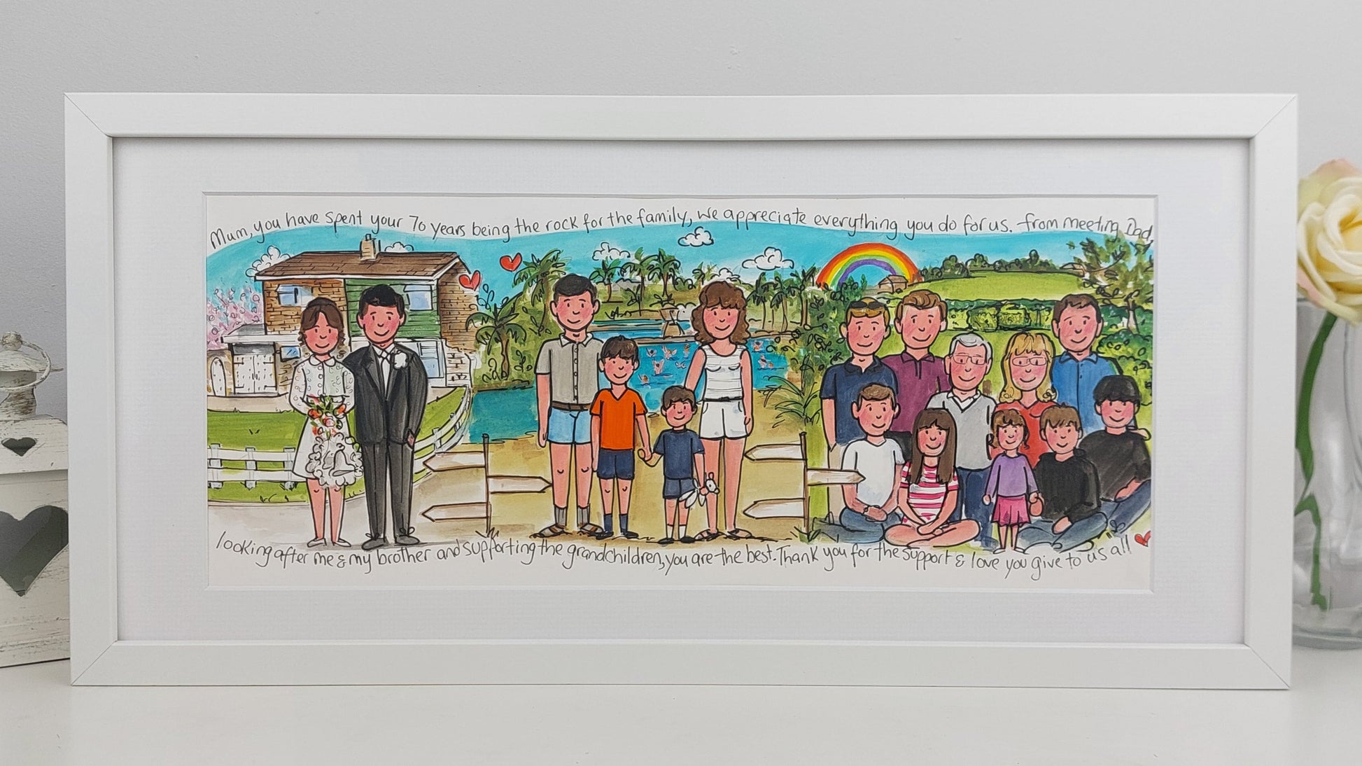 Framed artwork of a family portrait with a colorful background, displayed on a white surface.