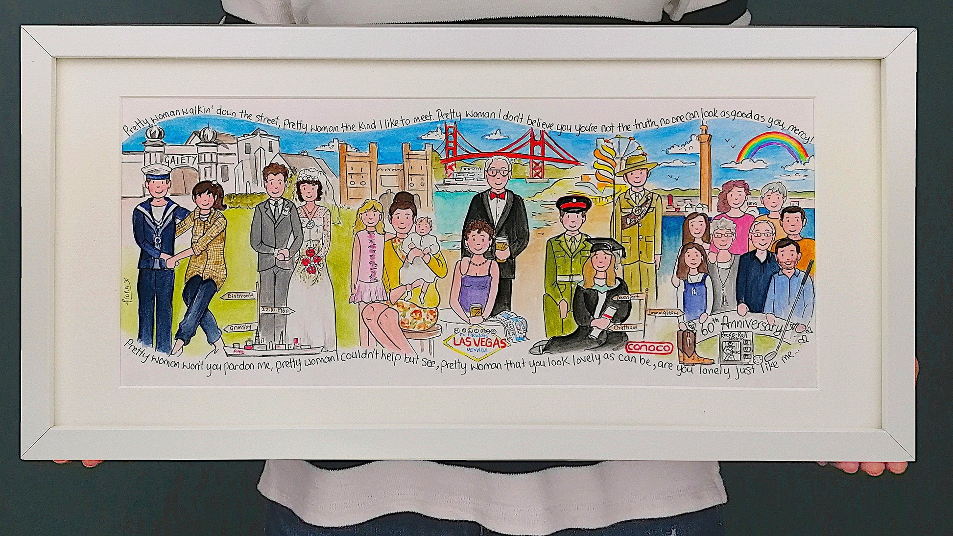 A colorful framed storyboard artwork featuring various cartoon characters and scenes, held by a person against a green background.
